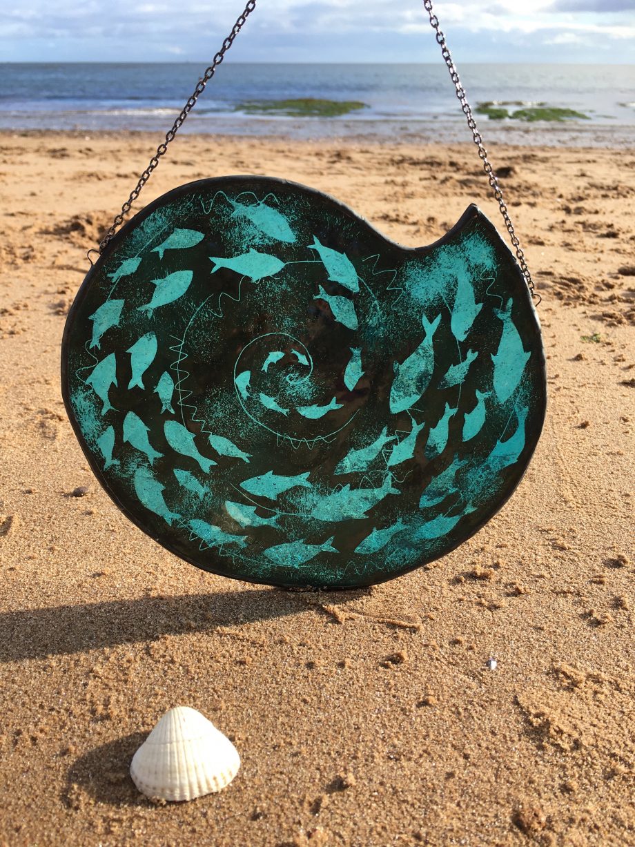 Stained glass fish spiral on beach