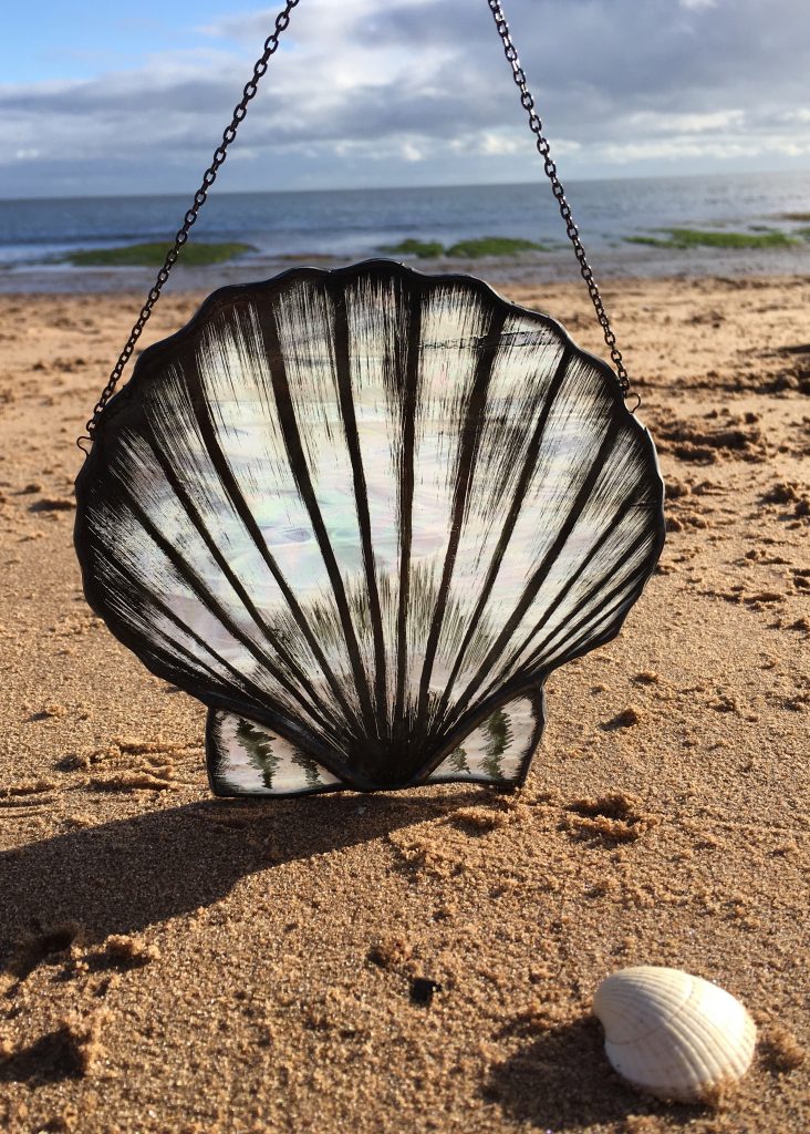 Stained glass scallop on beach