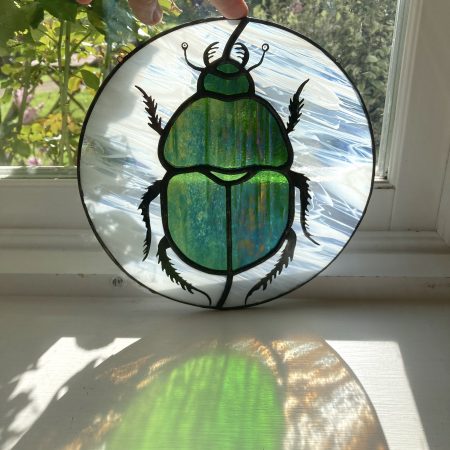 Scarab stained glass beetle sun catcher in light
