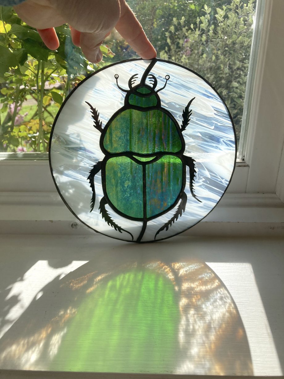 Scarab stained glass beetle sun catcher in light
